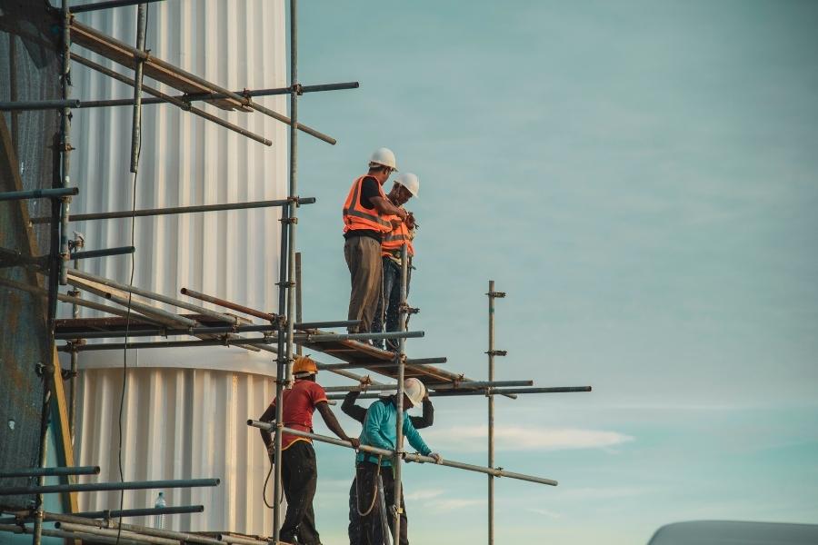 Un groupe de travailleurs en formation sur un chantier de construction, apprenant les techniques de La Taloche.