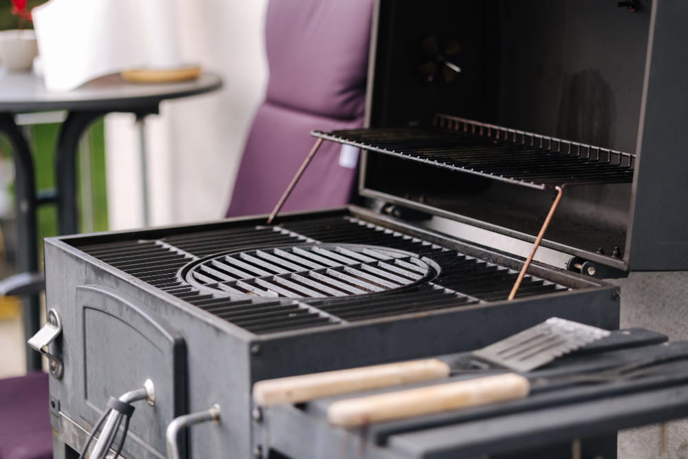 Gros plan sur la grille de cuisson en fonte d'un barbecue en inox noir pour le jardin
