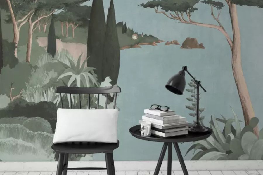 Un salon moderne aménagé avec un magnifique papier peint panoramique représentant un paysage côtier aux tons bleus et verts.